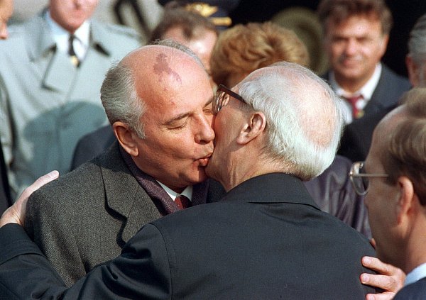 1989, DDR, Berlin: Der sowjetische Staats- und Parteichef Michail Gorbatschow (l.) wird nach seiner Ankunft zu den Feierlichkeiten zum 40-jährigen Staatsjubiläum der DDR in Ost-Berlin von Erich Honecker mit Bruderkuss begrüßt. - © Wolfgang Kumm