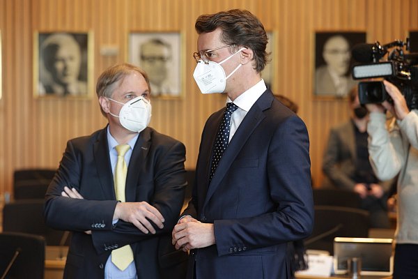 Hendrik Wüst (r, CDU), Ministerpräsident von Nordrhein-Westfalen, unterhält sich vor Beginn der Anhörung mit Ralf Witzel (FDP), dem Ausschuss-Vorsitzenden. - © picture alliance/dpa