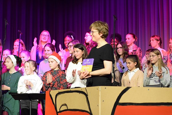 Stefanie Dermann ist als dritte Musikkraft am Niklas-Luhmann-Gymnasium tätig. Von den Sängerinnen und Sängern der Chor-AG der Jahrgangsstufen 5 bis 9 bekommt sie ein schokoladiges Dankeschön. - © Karin Prignitz