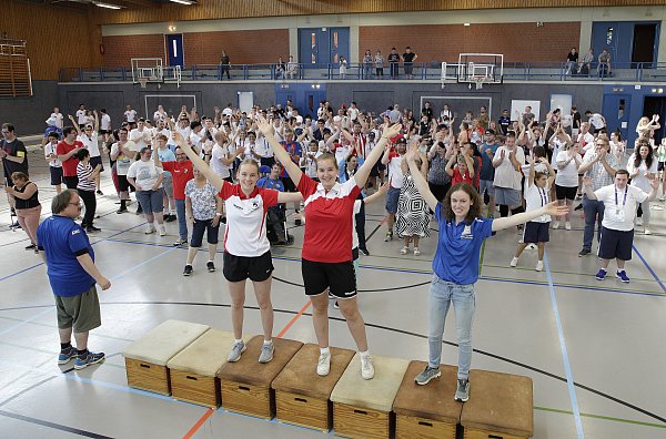 Aufwärmen zu Beginn des inklusiven Sportfestes Win-Together 2023 mit Paula Boß (v.l.), Anna Wegener (beide Stadtsportverband), Maren Schwede (Paderborner Sportservice) sowie Teilnehmern und Gästen. - © Agentur KlickVeröffentlichung nur gegen Honorarzahlung.
