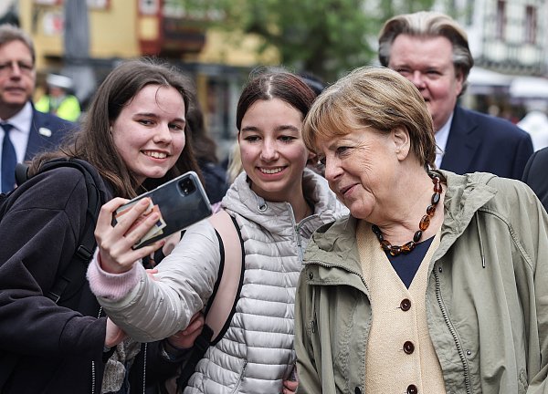 Angela Merkel macht beim Rundgang in Bad Münstereifel ein Selfie mit Schülerinnen. - © dpa