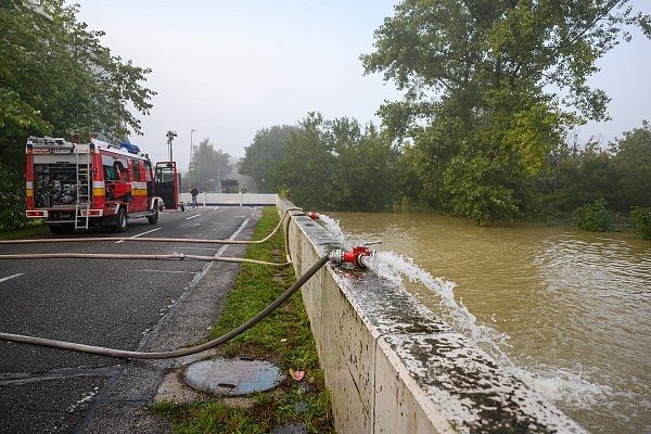 Slowakei, Bratislava: Feuerwehrleute stehen an einer Straße, die wegen Überschwemmungen im Bratislavaer Stadtteil Theben gesperrt ist. - © dpa