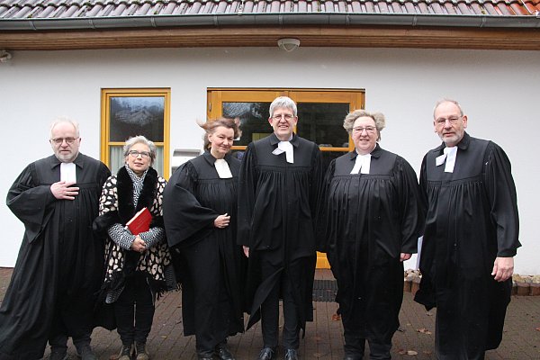 Pfarrer Volker Walle (v. l.), Verbandsvorstand Evelyn Schubert, Pfarrerin Christiane Zina, Superintendent Volker Neuhoff, Pfarrerin Elke Hansmann und Pfarrer Wolfgang Neumann im Sturmwind vor dem Nieheimer Gemeindehaus. - © Burkhard Battran