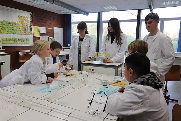 Lina (9, v. l.), Daniel (9) und ihre Klassenkameraden hören Hanna (15), Wiktoria (15) und Bogdan (16) im Duftlabor interessiert zu. - © Judith Gladow
