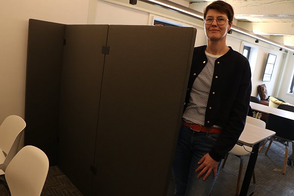 Stefanie Jonas vom Team der Stadtbibliothek mit einer der Trennwände, die Besuchende aufstellen können, um ungestörter arbeiten oder lernen zu können. - © Holger Kosbab