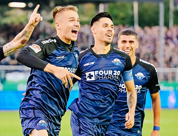 Filip Bilbija (l.), der hier mit dem Torschützen Rapael Obermair (M.) über die 2:1-Führung jubelt, erzielte in Münster einen Jubiläumstreffer. - © Besim Mazhiqi