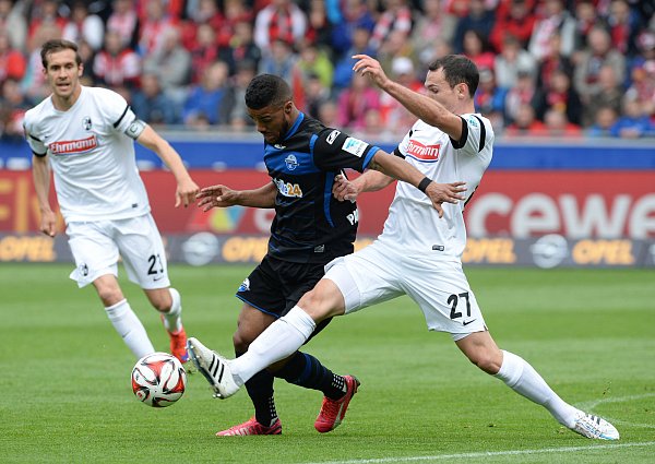 Elias Kachunga (M) und Nicolas Höfler (r) von Freiburg kämpfen um den Ball. - © dpa