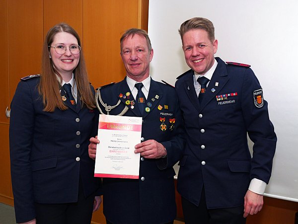 Heinz Linnemann (Mitte) ist seit 50 Jahren aktives Mitglied im Spielmannszug der Feuerwehr Paderborn. Zu diesem Jubiläum gratulieren die neue Zugführerin Sabrina Kruse (l.) und ihr Vorgänger Dennis Happe (r.). - © Ralph Meyer