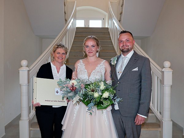 Außergewöhnliches Jubiläum: Antonia Breitensträter und Levin Babacan sind das 500. Brautpaar, das sich auf Schloss Benkhausen trauen ließ. Das freut auch Sonja Spilker, stellvertretende Leiterin von Schloss Benkhausen, die die Trauungen organisiert und jedes Mal ein Fotoalbum als Geschenk überreicht. - © merkur.com AG