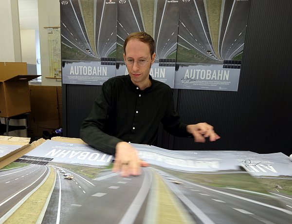 Regisseur Daniel Abma signiert eigenhändig 1.500 von der NW gesponserte Filmplakate für die Premiere von "Autobahn". Die Dokumentation über die Nordumgehung ist der Abschluss der Open-Air-Kinosaison. - © Thorsten Gödecker