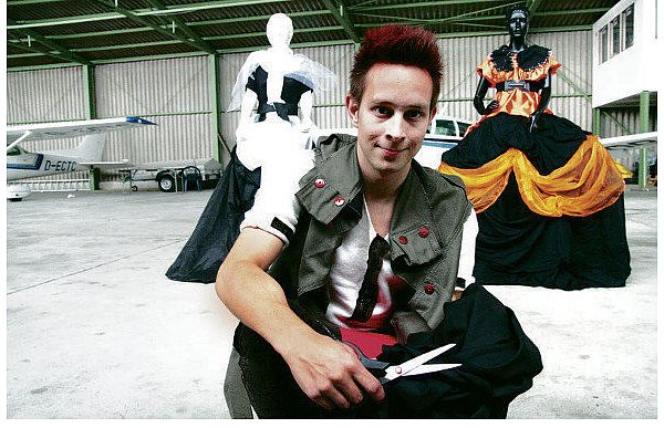 Nachwuchs-Modedesigner Marco Angel vor zwei extravaganten Kreationen in der Flugzeughalle am Räuschenberg, wo auch auch am Sonntag die Fashionshow stattfindet. - © FOTOS: BURKHARD BATTRAN
