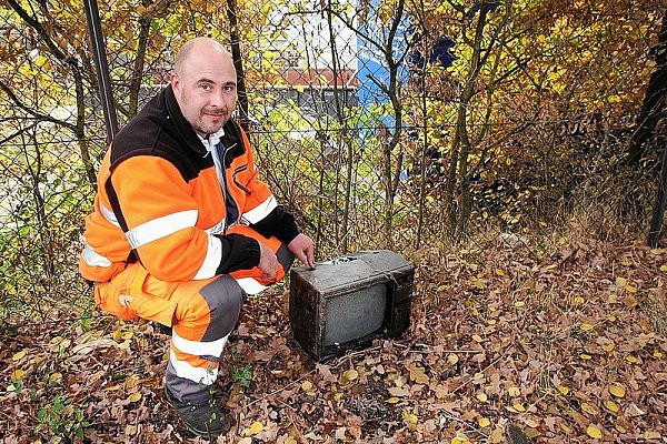 Im Schutz der Dunkelheit hat jemand den alten Fernseher über den Drahtzaun auf das Bauhofgelände geschleudert. Leiter Martin OToole kann sich nur wundern. - © FOTO: KARIN WESSLER