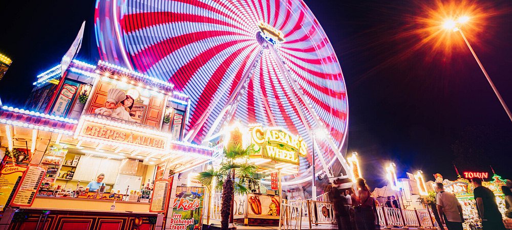 Das Riesenrad – mit 26 Gondeln und einer Höhe von 38 Metern – leuchtet abends in den buntesten Farben. - © Besim Mazhiqi