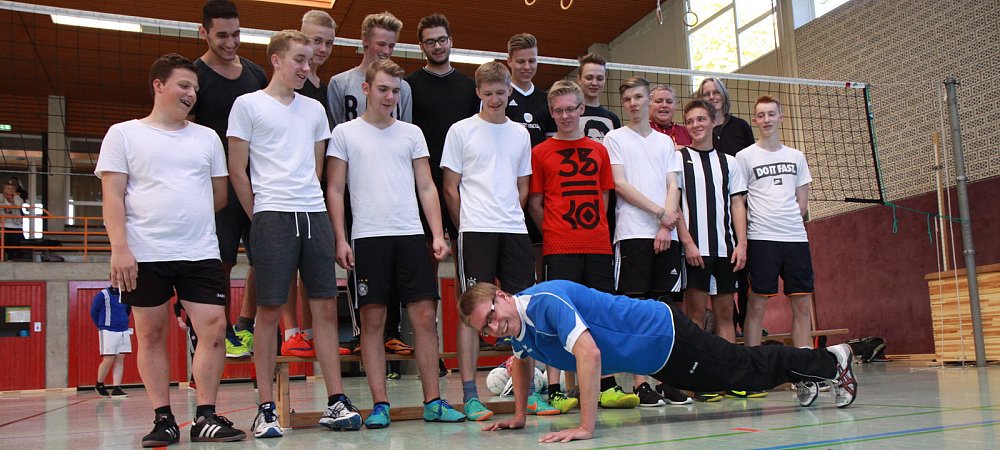 Liegestütze für den Teamerfolg: Sportlehrer Philipp von Detten löste bei der Siegerehrung eine Wettvereinbarung ein. Für den den Sieg und den zweiten Platz der beiden Teams des Gymnasiums Marianum im Volleyballwettbewerb der WK I absolvierte er 20 Liegestütze. Vorn das Siegerteam Marianum II, hinten der ältere Jahrgang mit den Lehrerinnen Monika Kröger-Mertens und Christin Raßmann. - © Ludwig