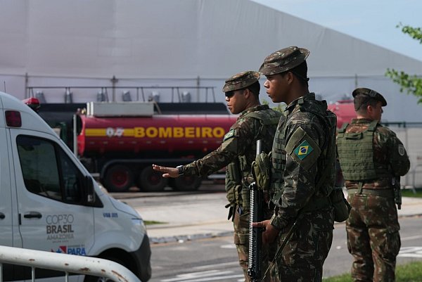 Sicherheitskräfte leiten Fahrzeuge nach einem Brand auf dem Gelände der Weltklimakonferenz. - © Fernando Llano/AP/dpa