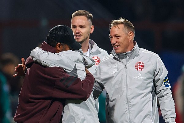 Pure Freude: Trainer Daniel Thioune umarmt nach dem Spiel seine Co-Trainer. - © Christoph Reichwein/dpa