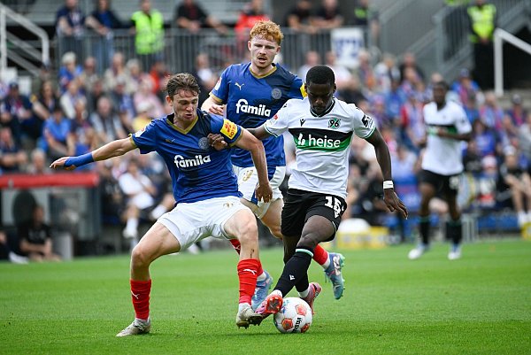 Kiels Magnus Knudsen (l) im Duell mit dem Hannoveraner Noel Aseko. - © Gregor Fischer/dpa