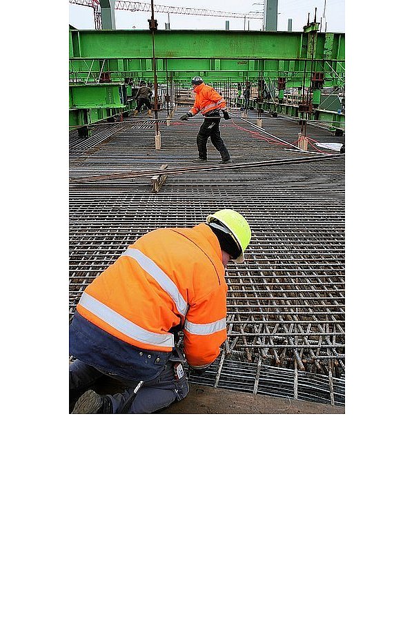 Bauarbeiter verbinden die Stahlmatten, die die Betonfahrbahn über die Werre stabilisieren sollen. Während der Brückenschlag gut voran geht, verzögert sich der Bau des Tunnels, der sich an die Brücke anschließen soll. - © FOTO: PETER STEINERT