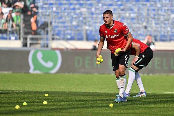 Nicolò Tresoldi hebt Tennisbälle vom Spielfeld auf. - © Swen Pförtner/dpa