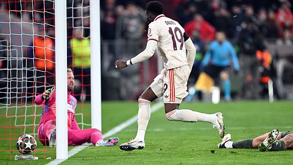 Alphonso Davies stochert den Ball ins Tor, am Boden Celtic-Torwart Kasper Schmeichel (l). - © Sven Hoppe/dpa