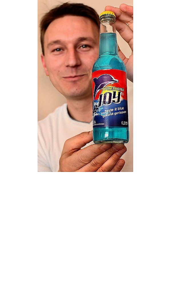 Kresimir Rubil zeigt sein bläulich-schimmerndes Erfrischungsgetränk "Joy". Der Delfin auf dem Logo soll für Intelligenz und Ausdauer stehen. - © FOTO: PATRICK MENZEL