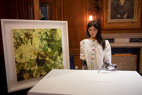 Ai-Da, die weltweit erste Roboterkünstlerin, steht während ihrer Vorstellung auf einer Pressekonferenz am Lady Margaret Hall College der Oxford University neben einem eigenen Kunstwerk. - © Jacob King/PA Wire/dpa