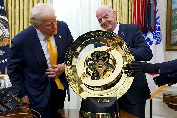 Der US-Präsident (l.) und der FIFA-Boss (r.) betrachten die Trophäe für die Club-WM. - © Uncredited/Pool/AP/dpa