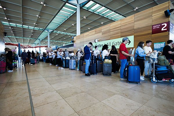 Lange Warteschlangen bildeten sich bei der Abfertigung von Passagieren am Berliner Flughafen. - © Carsten Koall/dpa