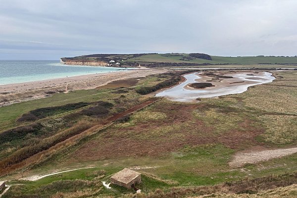 Der Blick von Haven Brow auf Cuckmere Haven: Bei Ebbe kann man den Strand queren, bei Flut ist das zu gefährlich. Der Umweg zur Brücke landeinwärts lohnt sich aber. - © Nathalie Helene Rippich/dpa-tmn