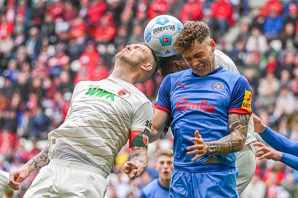 Rasant ging es zu auf dem Platz. Kiels Nicolai Remberg (r) und Augsburgs Kapitän Jeffrey Gouweleeuw beim Kopfballduell. - © Armin Weigel/dpa