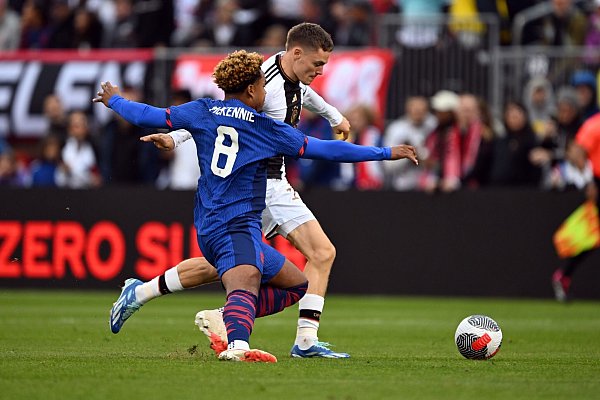 Deutschlands Florian Wirtz (r) im Zweikampf mit dem US-Amerikaner Weston McKennie. - © Federico Gambarini/dpa