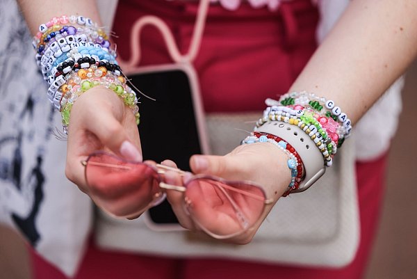 Selbstgemachte Freundschaftsbändchen aus bunten Perlen und Steinen gehören für echte «Swifties» zum Konzert-Outfit. - © Oliver Berg/dpa