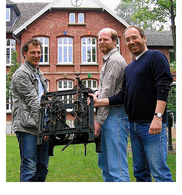 Uhrmachermeister André Haselhorst, Hausmeister Olaf Brinkschneider und Schulleiter Gerhard Dickers (v.l.) mit dem Chronometer, den Haselhorst reparieren wird. - © FOTO: CONRAD SCHORMANN