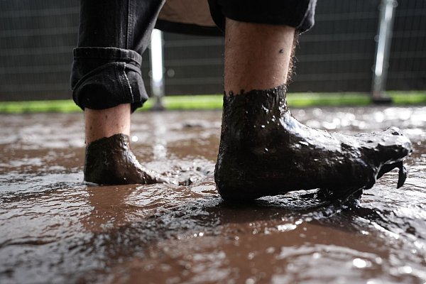 Die Besucherinnen und Besucher lassen sich von dem Wetter beim Wacken Open Air nicht abschrecken. - © Marcus Brandt/dpa