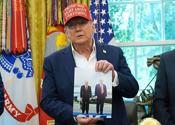 Trump zeigt ein Foto von sich und Putin. - © Jacquelyn Martin/AP/dpa
