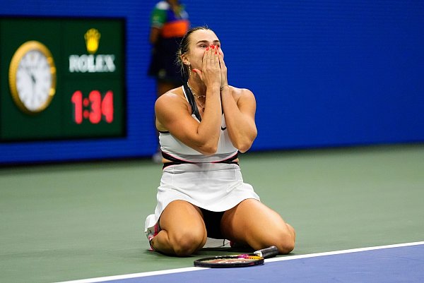 Aryna Sabalenka sackte nach dem Erfolg überglücklich auf den Boden. - © Yuki Iwamura/AP/dpa