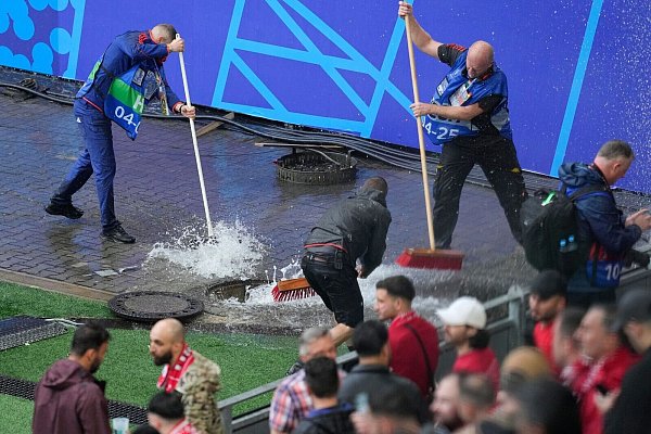 Kampf gegen die Wassermassen: Mitarbeiter sind vor dem Spiel Türkei gegen Georgien im Stadion im Einsatz. - © Andreea Alexandru/AP