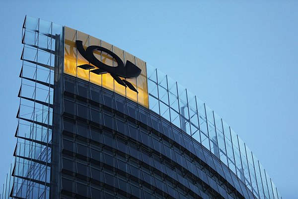 Das Logo der Deutschen Post leuchtet am Post-Tower, dem Unternehmenssitz des Post-Konzerns DHL. - © Oliver Berg/dpa