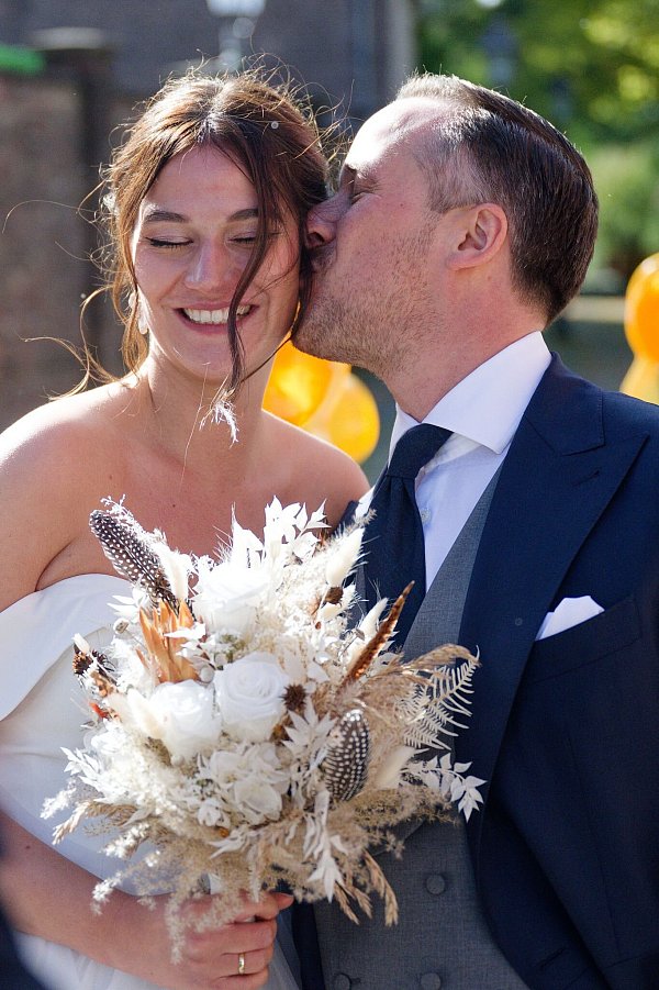 Nach der Hochzeit küsst Joe Laschet vor der Kirche seine Frau Andrea - © Henning Kaiser/dpa