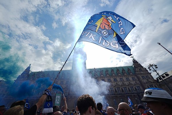 HSV-Fans stehen auf dem Rathausmarkt vor dem Hamburger Rathaus und feiern ihren Club. - © Marcus Brandt/dpa