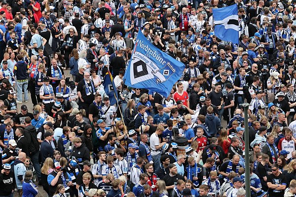 HSV-Fans stehen auf dem Rathausmarkt vor dem Hamburger Rathaus und feiern ihren Club. - © Christian Charisius/dpa