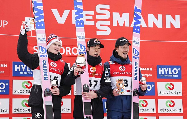 Bei den Siegerehrungen können die deutschen Skispringer derzeit nur zuschauen. - © Uncredited/Kyodo News/AP/dpa