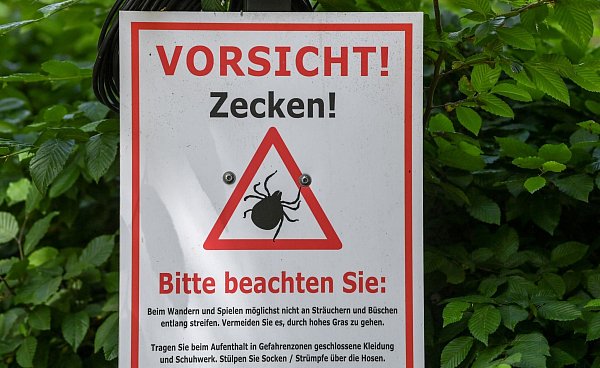 Warnschilder liefern oft auch Hinweise, wie man sich vor Zeckenstichen schützen kann. (Archivbild) - © Jens Kalaene/dpa-Zentralbild/dpa