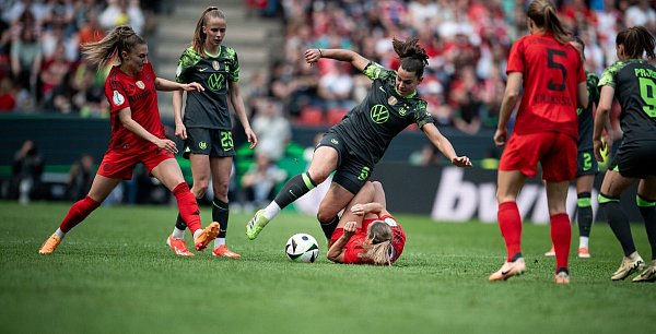 Noch in Wolfsburg, bald beim FC Bayern: Lena Oberdorf (M) im Zweikampf. - © Fabian Strauch/dpa