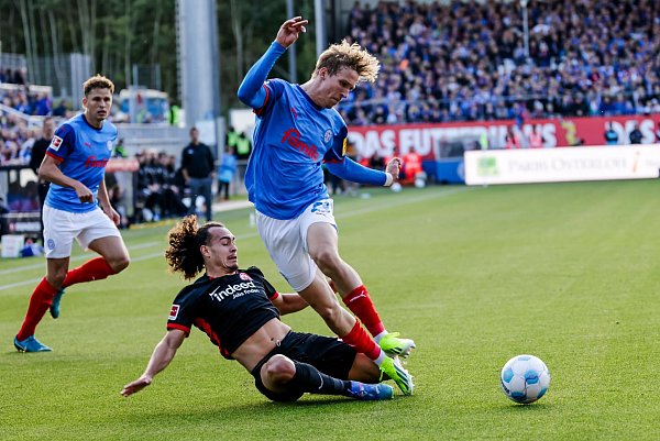 Zweikampf um den Ball: Frankfurts Arthur Theate (l.) und Kiels Lasse Rosenboom. - © Frank Molter/dpa