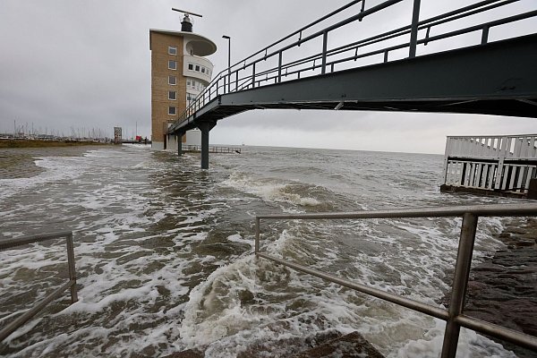 An der Alten Liebe überschwemmt die Nordsee bei einer Sturmflut das Hafengebiet. - © Christian Butt/dpa