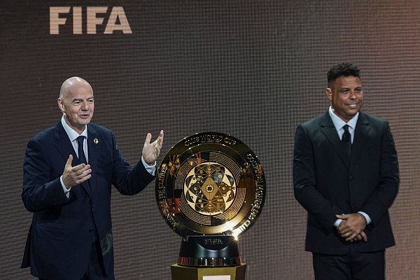 FIFA-Präsident Gianni Infantino und der frühere brasilianische Fußballstar Ronaldo präsentieren bei der Auslosung der Club-WM die Siegertrophäe. - © Rebecca Blackwell/AP/dpa