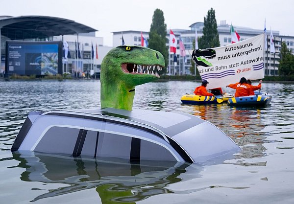 Schon vor der offiziellen Eröffnung protestierte Attac mit einem «Autosaurus» am Münchner Messegelände. - © Sven Hoppe/dpa