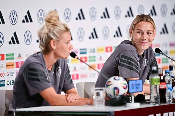Linda Dallmann (l.) und Sarai Linder erklären die Situation nach dem EM-Aus für Giulia Gwinn - © Sebastian Christoph Gollnow/dpa