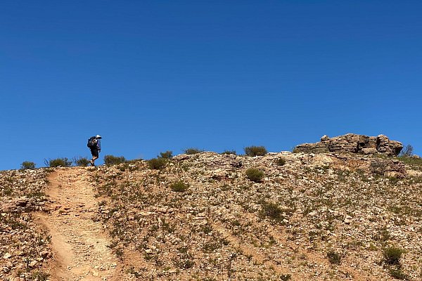 Wander-Guide Ian Vickers führt durch die von Spinifex-Süßgras gesprenkelte Canyon-Landschaft im Nationalpark. - © Stefan Weißenborn/dpa-tmn